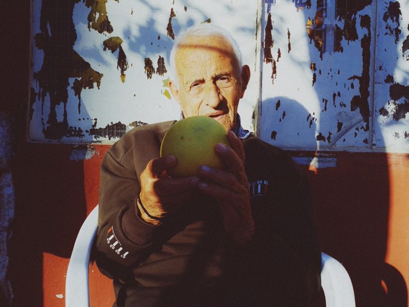 © Habib Saleh - A candid portrait of a man holding a pomelo fruit in the town of Joun, Lebanon 2024.