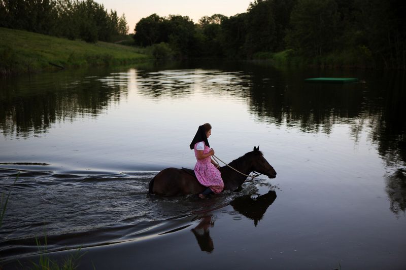 © Tim Smith - August 5, 2016 Hadassah Maendel takes Kahlua for a swim in the pond at Baker Colony at sunset on a warm August evening.