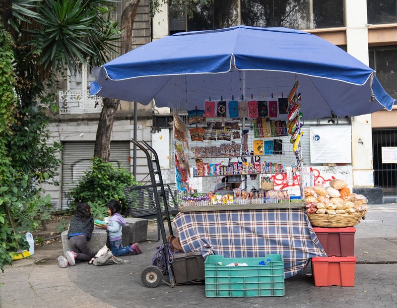 © Roxanne Munson - Two little girls talking next to a snack food stand.