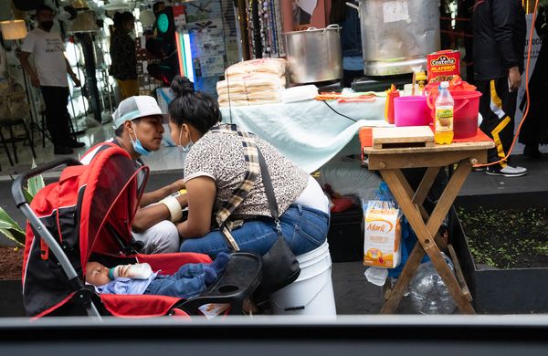 © Roxanne Munson - A man and woman showing affection with a baby beside them.