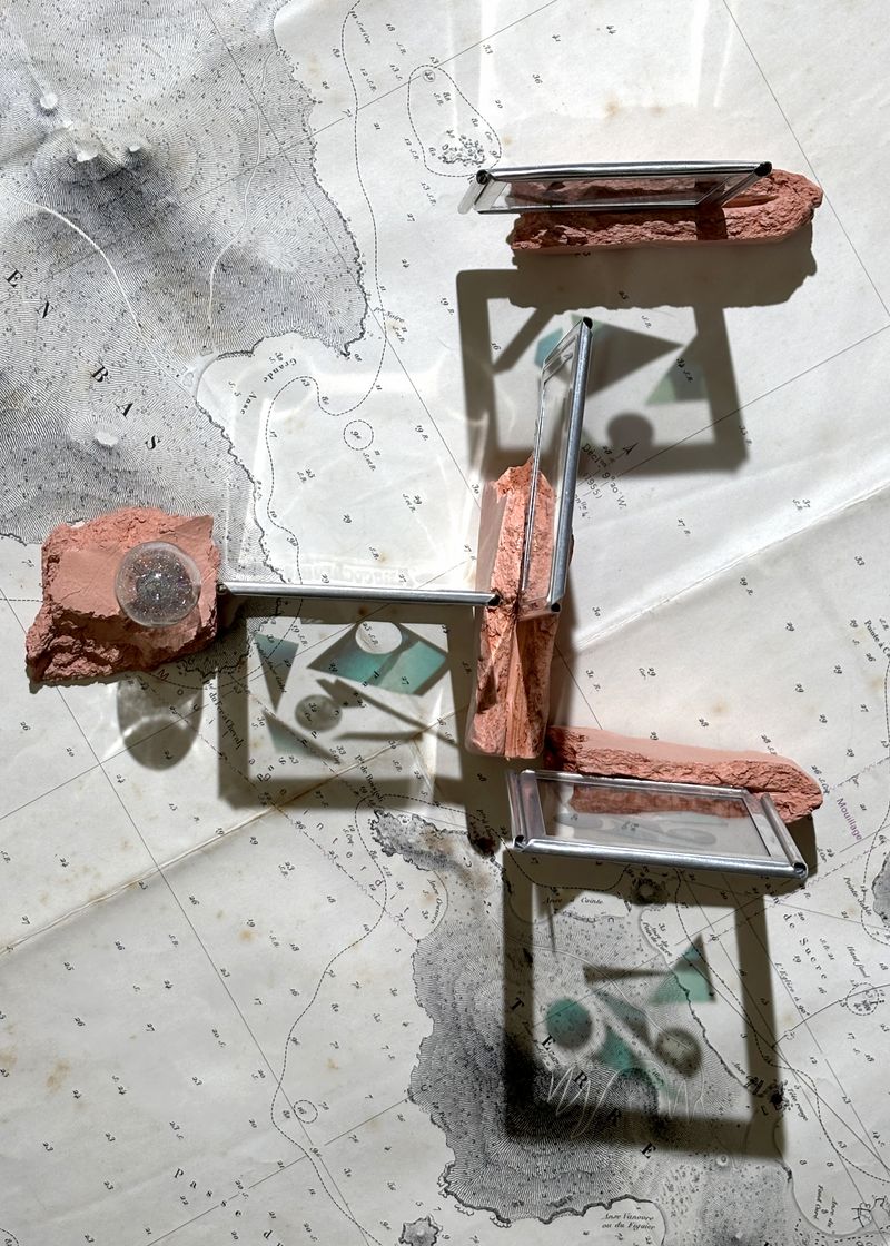 © Charalambos Artemis - Nautical chart, fragmented photographic sailing archive in 6x6cm Anscochrome metal slide mounts, clay. Dimensions variable.