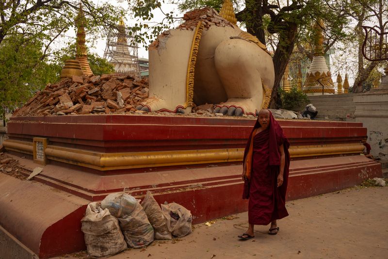 © Patrick Chengzhi Wang - A monk walks by a collapsed statue of mythical beast in Mandalay, Myanmar.