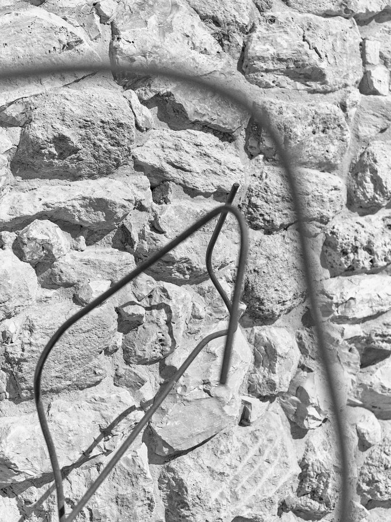 © Hamzeh Zahran - Wires Against the Old Stone Wall, Amman Citadel, Amman, 2025, from the "Remains" series