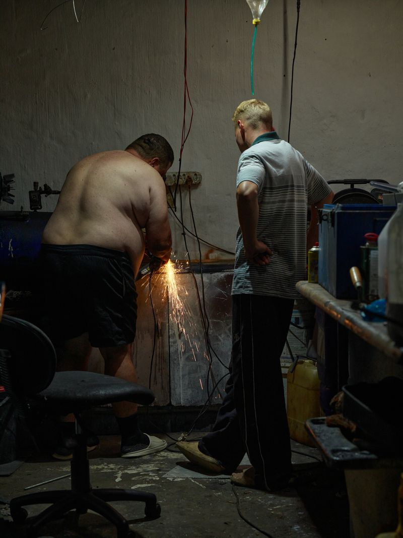© Anton Bossenbroek - Dawie and Heinrich sharpening my panga, Secunda, 2025