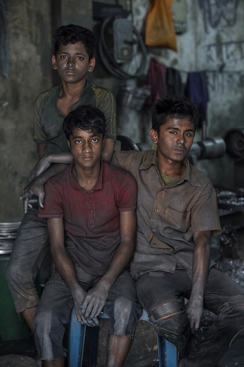 © Valerie Leonard - FRIENDSHIP. ￼Imran (13), Nizam (14) and Hossain (15), work in an aluminum pot factory. They make 1$ a day.
