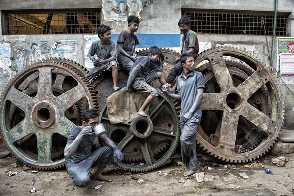 © Valerie Leonard - MODERN TIMES. Lunch break on old tanker wheels in aluminium factories.
