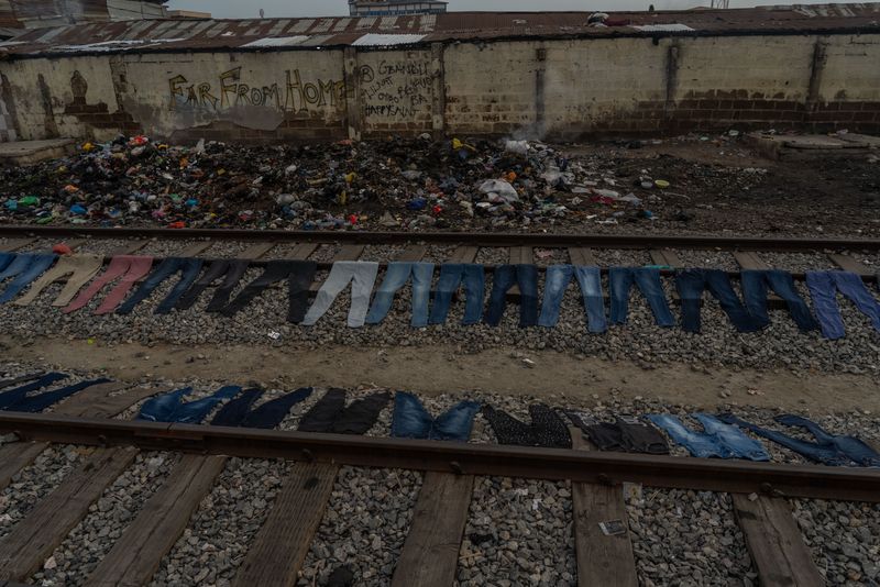 © Natalija Gormalova - Freshly dyed jeans drying along the train tracks just outside Kantamanto market, awaiting resale.