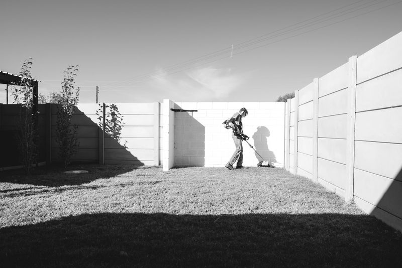 © Nadia Ettwein - A young boy from Orania, cuts the lawn with a weed eater as part of his gardening service.