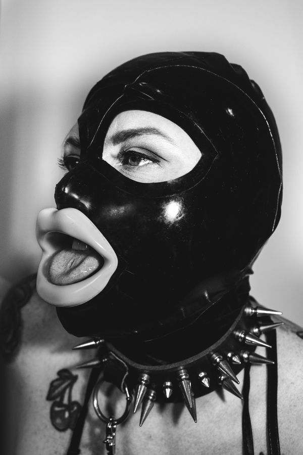 © Nadia Ettwein - Miss Luscious Lips, 2024. Portrait of miss Luscious lips wearing a latex mask. Obedience as costume.
