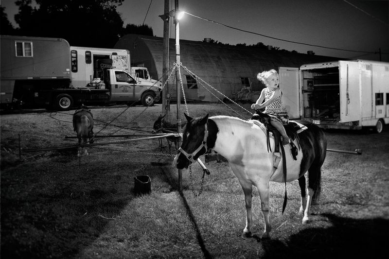 © Lieh Sugai - Child on a pony outside the tent in Brooklyn, Iowa.