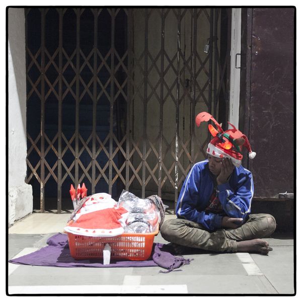 © Vijay S. Jodha - Teenager wearing all three times he is selling, waits for customers.