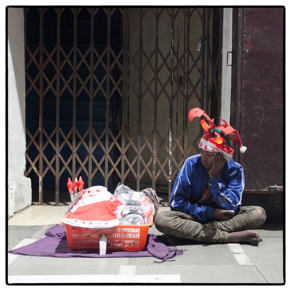 © Vijay S. Jodha - Teenager wearing all three times he is selling, waits for customers.
