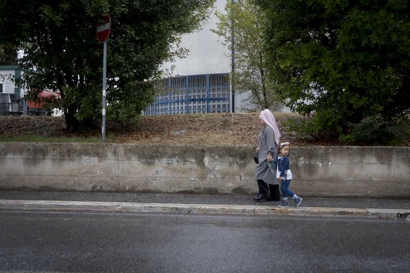 © Claudia Borgia - A mother and her daughter walking together through the streets of the neighborhood.