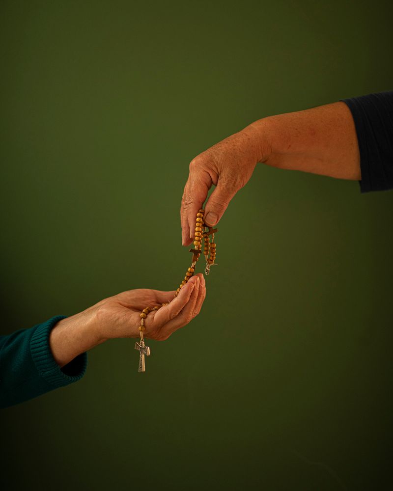 © Margarita V Beltran - Rite My aunt offers a rosary to my mother.