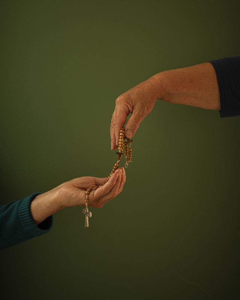 © Margarita V Beltran - Rite My aunt offers a rosary to my mother.
