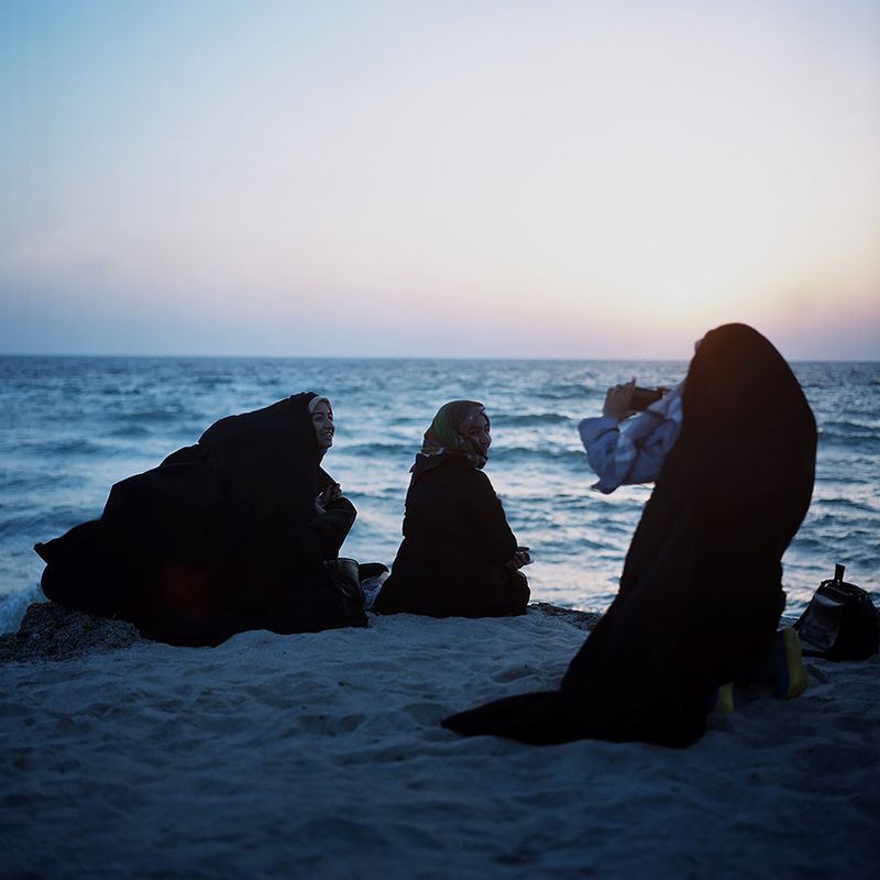 © Loulou d’Aki - Down by the water, Iranian girls in chador take pictures of each other at sunset on Kish island.
