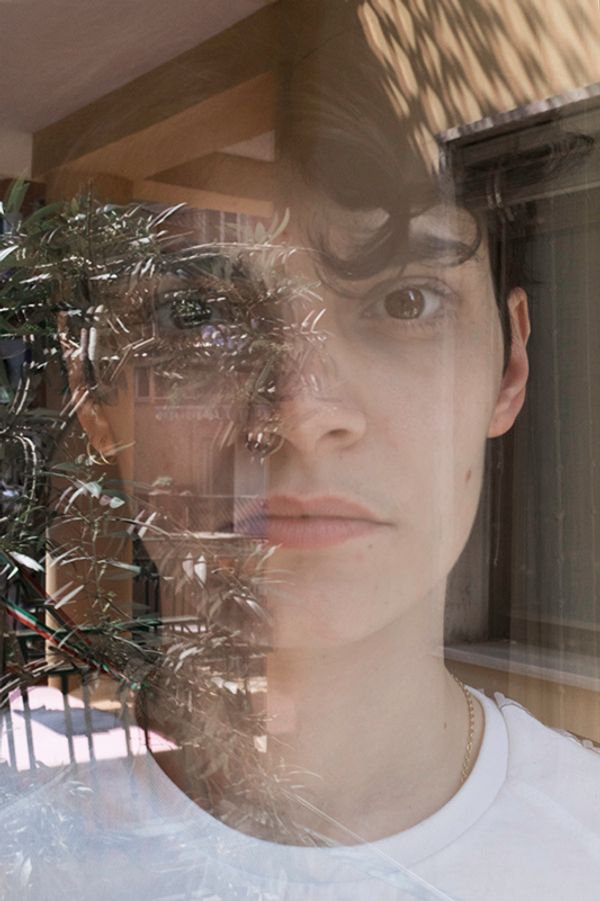 © Maria Giulia Trombini - Nico through a window at the home of Ludovica, his girlfriend. Naples, March 2021