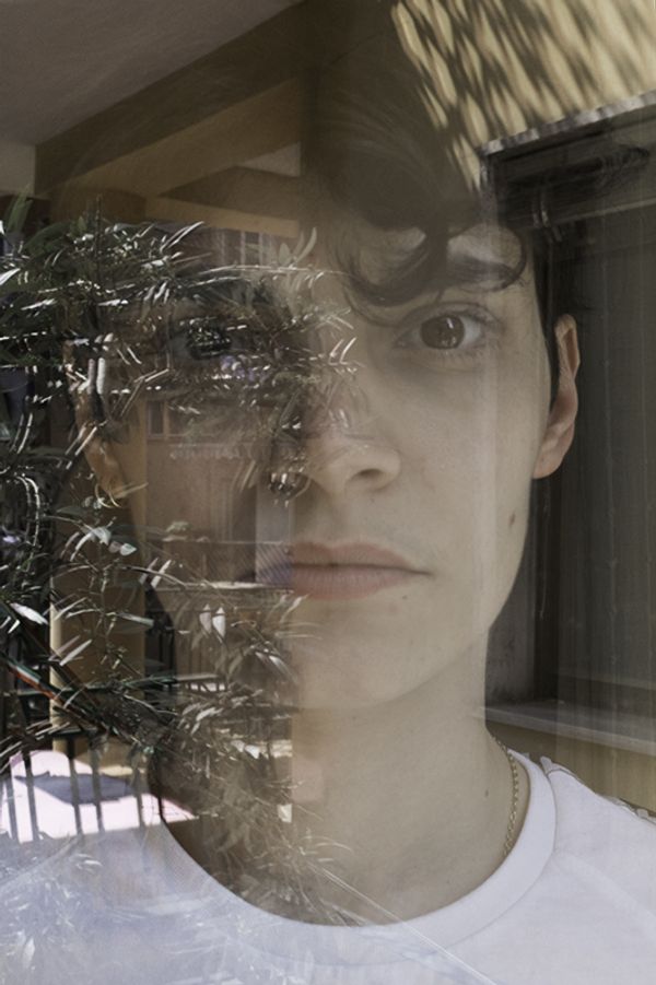 © Maria Giulia Trombini - Nico through a window at the home of Ludovica, his girlfriend. Naples, March 2021