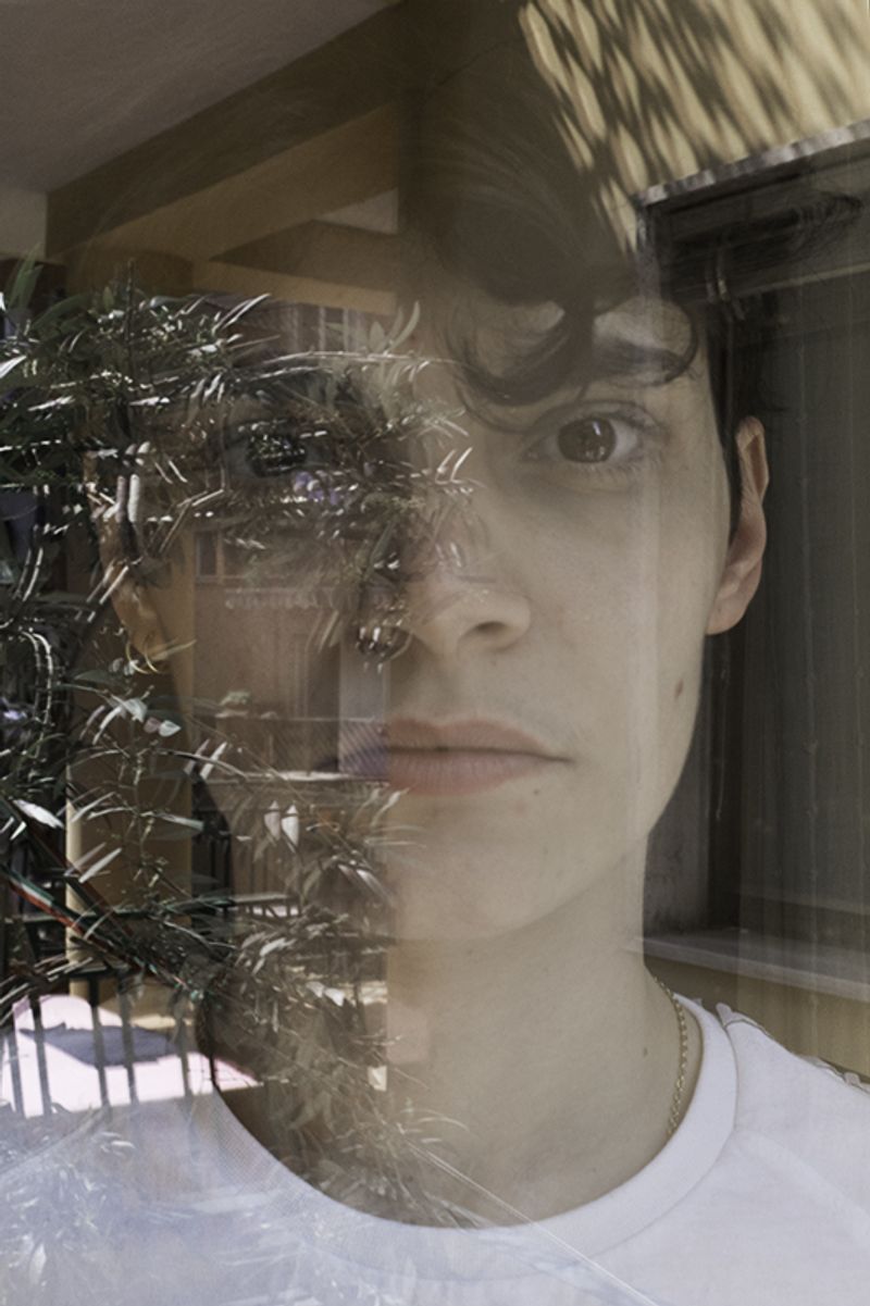 © Maria Giulia Trombini - Nico through a window at the home of Ludovica, his girlfriend. Naples, March 2021