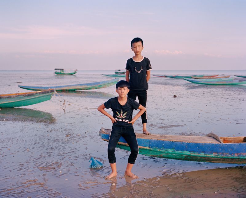© liang chen - Two teenagers pick up snails on the beach。  Donghai Island, Guangdong Province, China, 2018