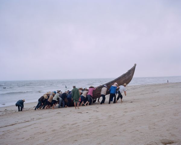 © liang chen - After fishing, the villagers joined hands to get the boat ashore. 2014 Donghai Island, Guangdong Province, China