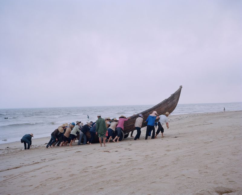 © liang chen - After fishing, the villagers joined hands to get the boat ashore. 2014 Donghai Island, Guangdong Province, China