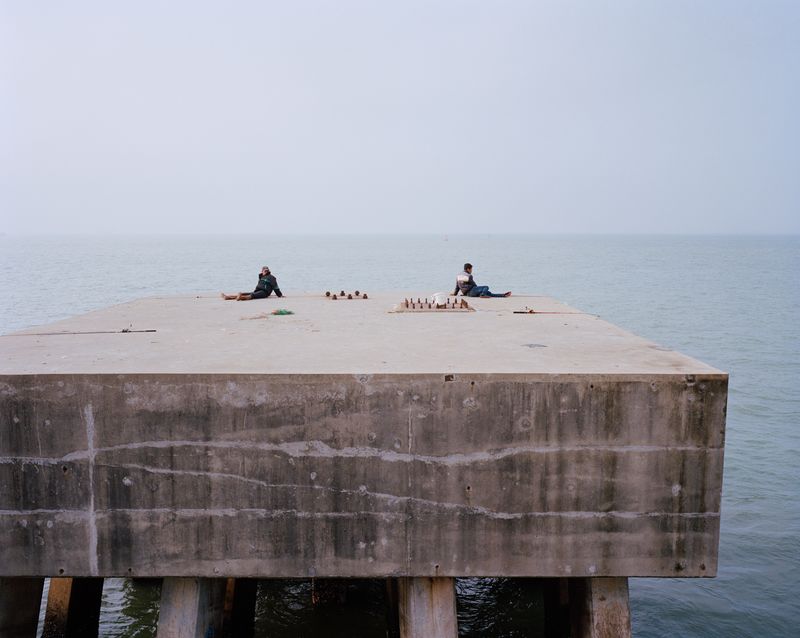 © liang chen - The young man fishing in the Zhanjiang Steel Factory.  2013  Guangdong Province, Donghai Island, China
