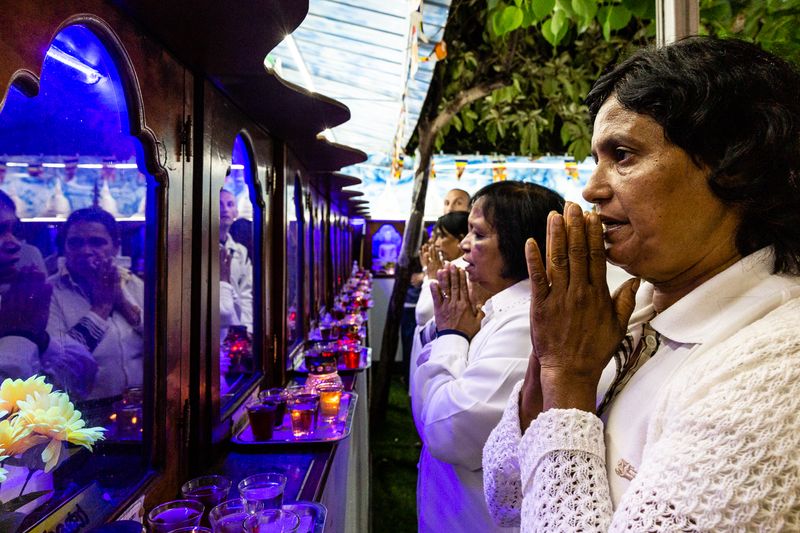 © Giovanni Lo Curto - Tamil worshippers pray in front of all the Buddha reincarnation. Catania, Italy. 2018.