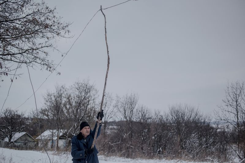 © Valery Melnikov - . A man repairs a power line destroyed by shelling in the village of Donetskyi, Lugansk region.