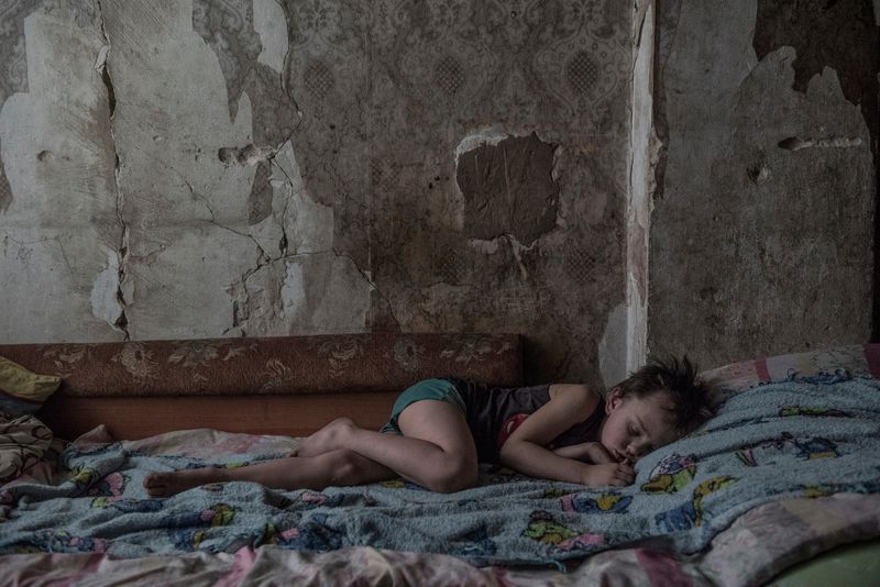 © Valery Melnikov - . A child in a house near the front line. Outskirts of Donetsk. Ukraine