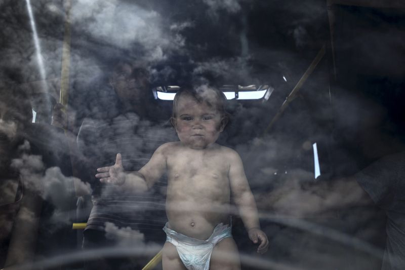 © Valery Melnikov - Refugee family and their child in the bus at the Izvarino border crossing point