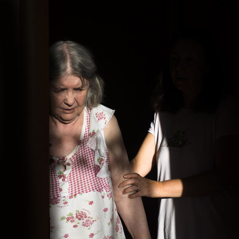 © Maria Quigley - Svetlana leads Babushka down the apartment hallway. It's becoming more difficult for her to walk each year.