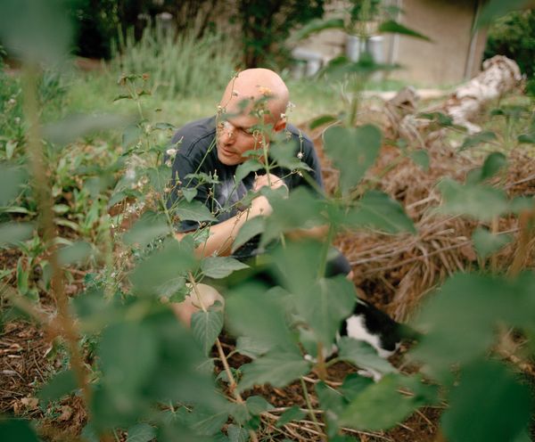 © Dana Golan - Elad tending to the garden and stopping to pet the local stray cat that Avigail feeds.