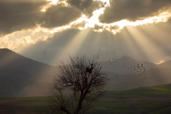© Farbod Bavehie - Sunlight breaks through dense clouds over the mountainous slopes of Kurdistan at the beginning of the Nowruz celebrations.
