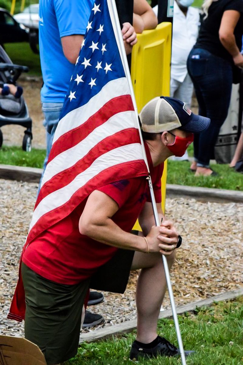 © Ash Esposito ~ Little Box of Random - Protester with a flag and symbolically taking a knee