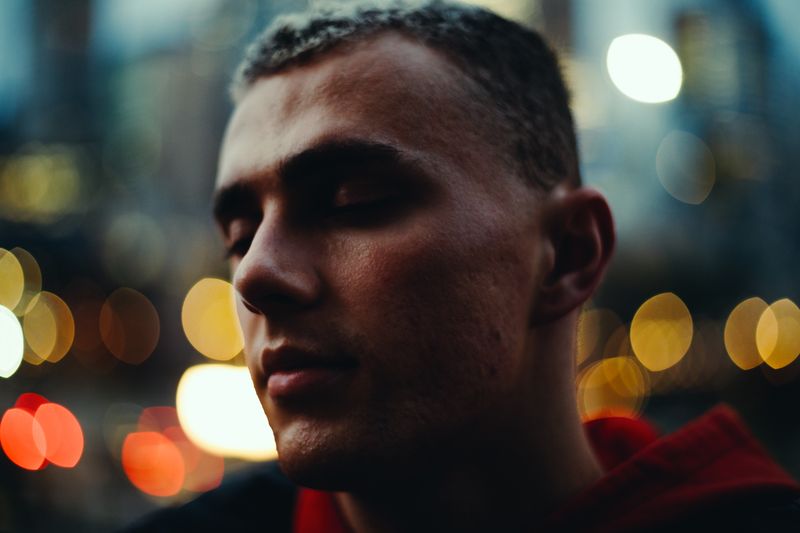 © Ryley Clarke - Close up of a young persons' face surrounded by the cities light and bokeh.