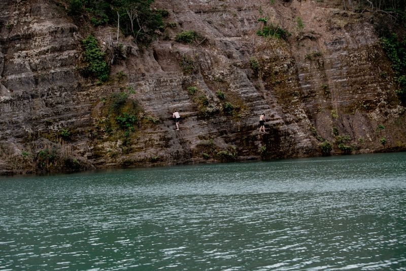 © Tajette O'halloran - A boy climbing to jump from the cliff