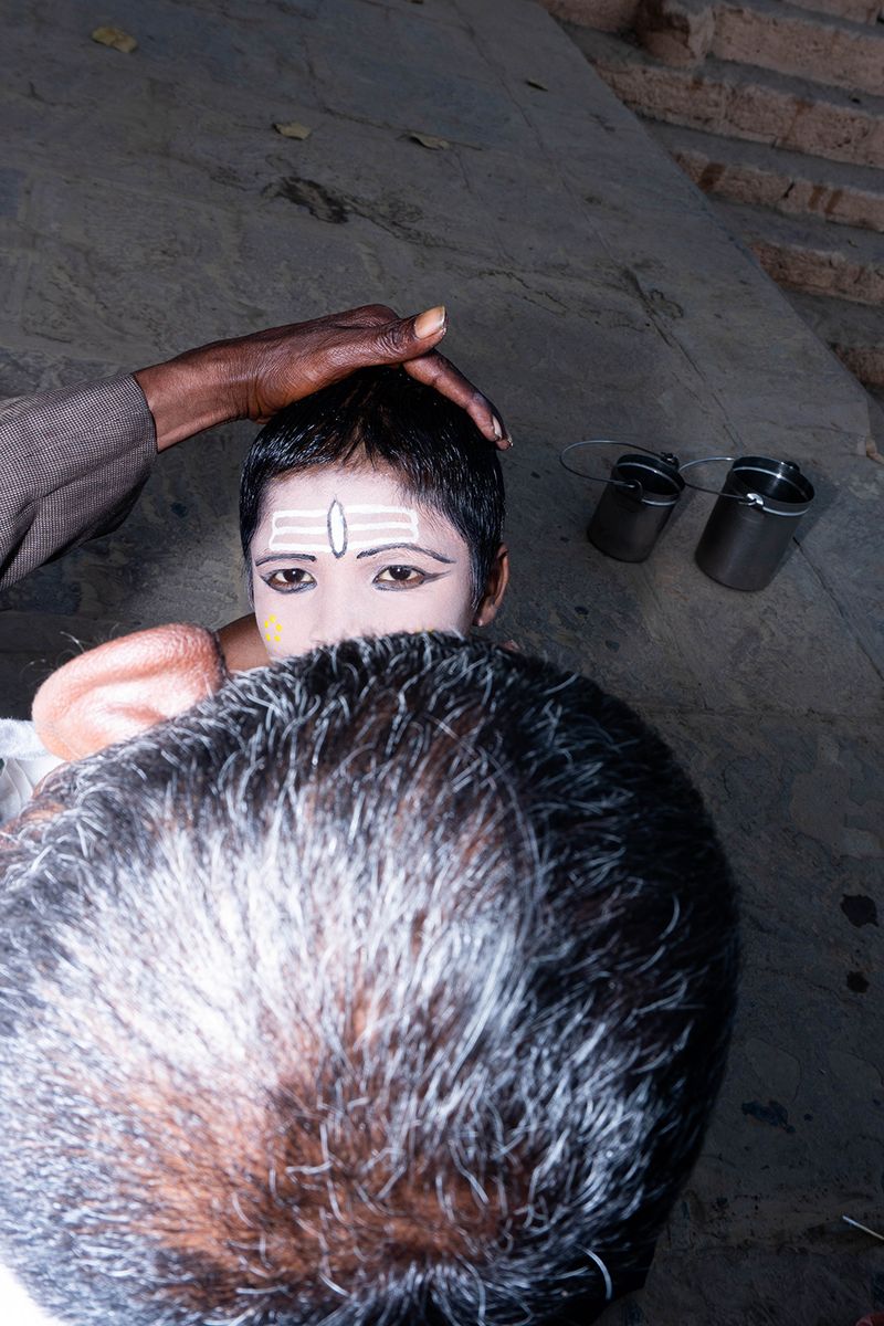 © Kanrapee Chokpaiboon - A boy being face painted to represent Shiva God.