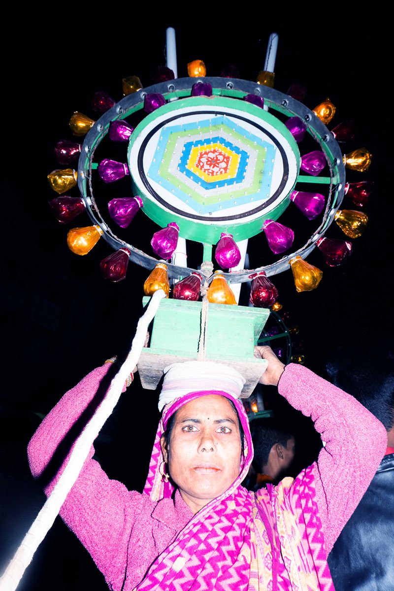 © Kanrapee Chokpaiboon - Woman holding some kind of festive lamps during a big parade. She is a part of a line of people holding similar lamps.