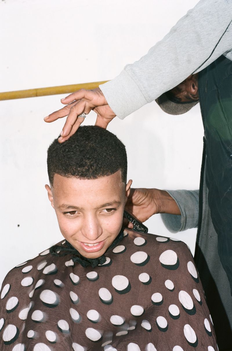 © Daniel Guix - Kid getting a haircut at the beach of Tilit