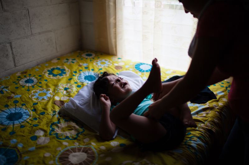 © Anneke Paterson - Angelica is dressed by her mom in their home in Usulután, El Salvador. 2017.