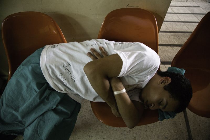 © Anneke Paterson - A young man rests while he awaits his procedure. Central Military Hospital, San Salvador, El Salvador, 2016.