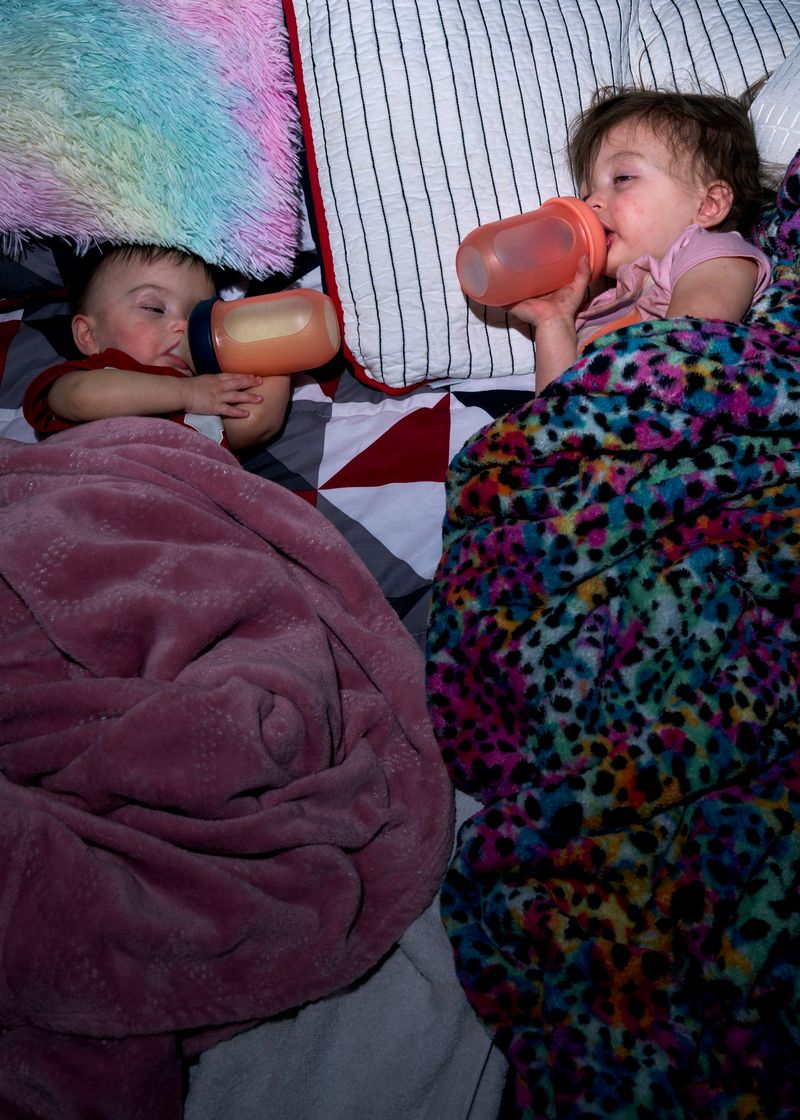 © Stacy Kranitz - Elayna and Zoey fall asleep in their parent's bed.