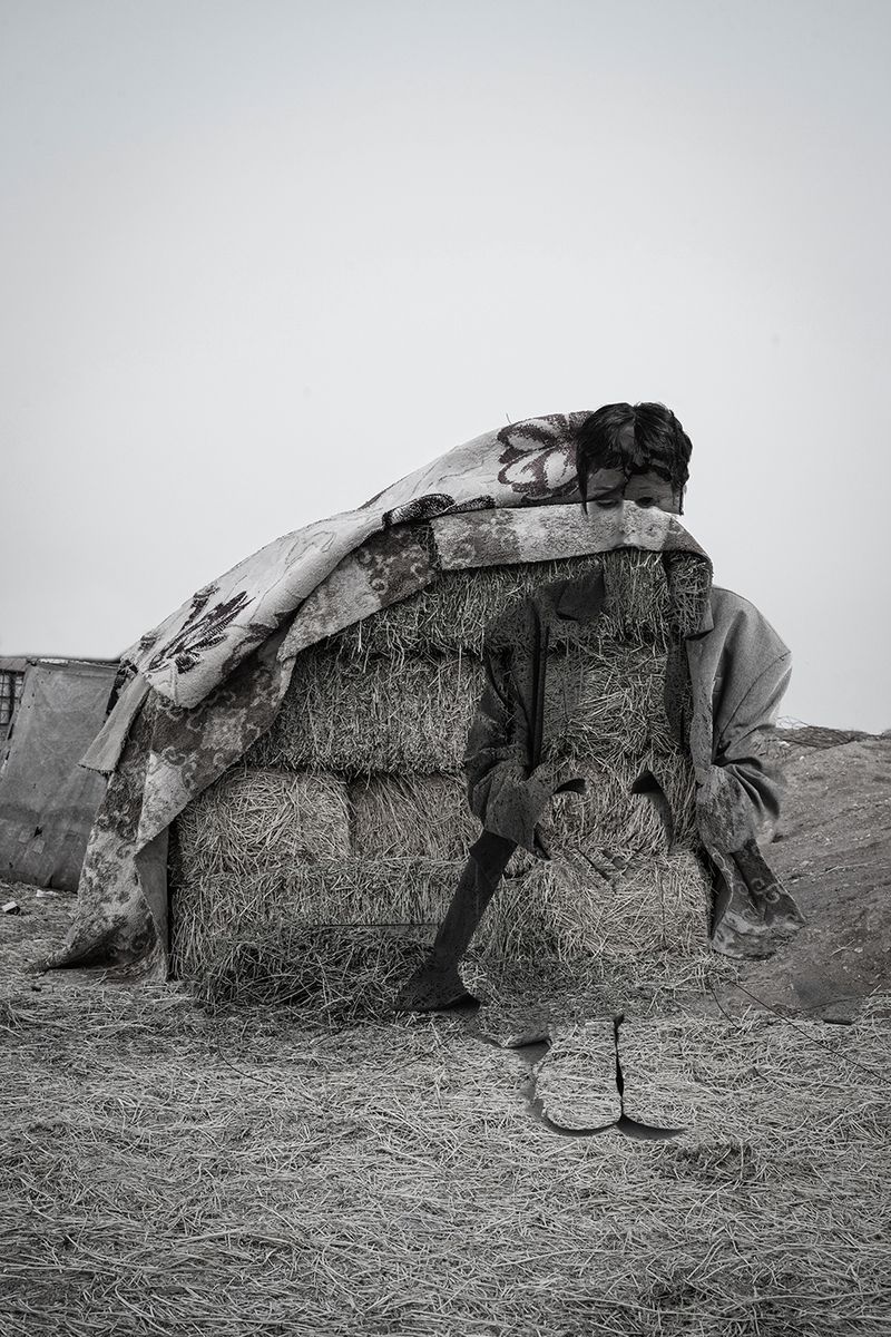 © andrea alkalay - Digital collagewoman sitting in a Bedouin camp with straw mats, camel feed
