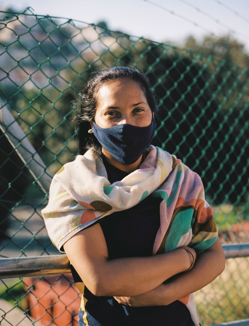 © Ayesha Kazim - A woman stands for a portrait while waiting to receive lunch from the Bo Kaap Cultural Hub.
