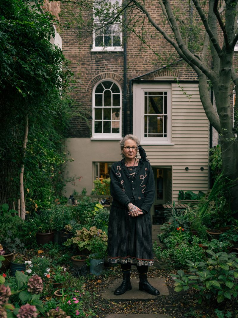 © Fotómetro - Carey in her garden, with her home made crow doll.