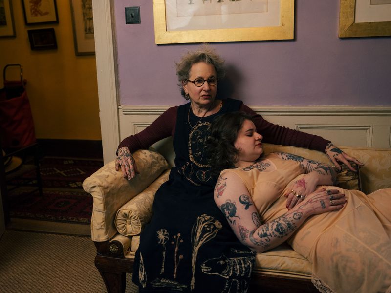 © Fotómetro - Lois lying on Carey's lap in their living room.