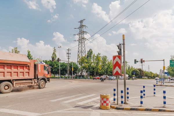 © Tianhu Yuan - Dust and Sun. A construction truck kicks up dust under the harsh, direct sunlight.