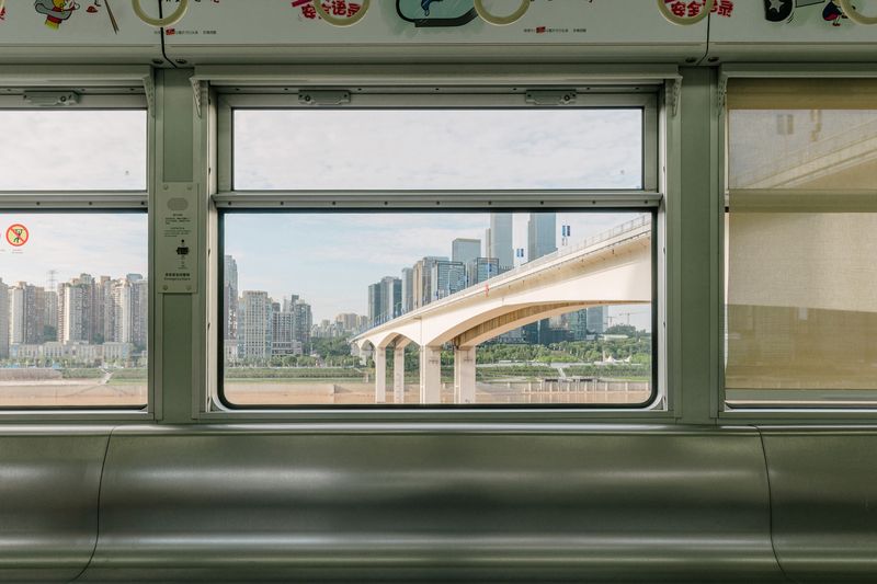 © Tianhu Yuan - Beyond The Window. The train travels along the river. Beyond the window lies the financial heart of Chongqing.