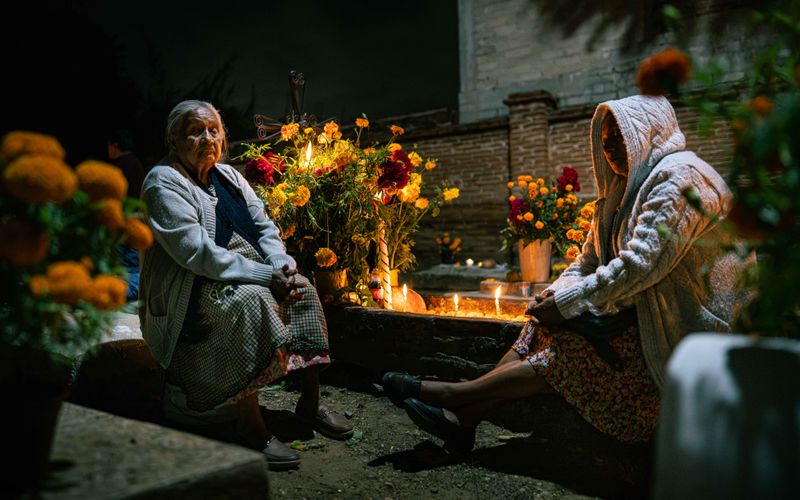 © Hong Yu Chan - Two figures sit in stillness, their silence illuminated by candlelight.